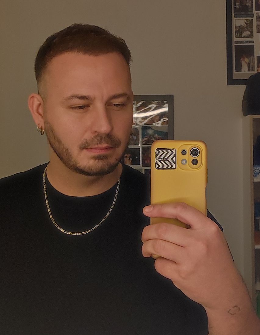 Man in a mirror around eight months after a hair transplant with styled hair
